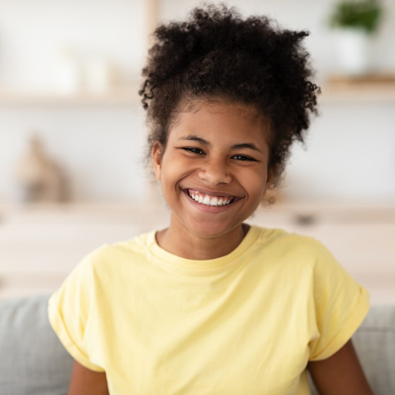 Positive Black Girl Laughing Sitting On Couch At Home
